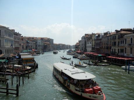 Explore Venice's Grand Canal with boats and historic buildings along the water.