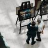 A high-angle view of people observing art exhibits in a gallery, showcasing creativity and culture.